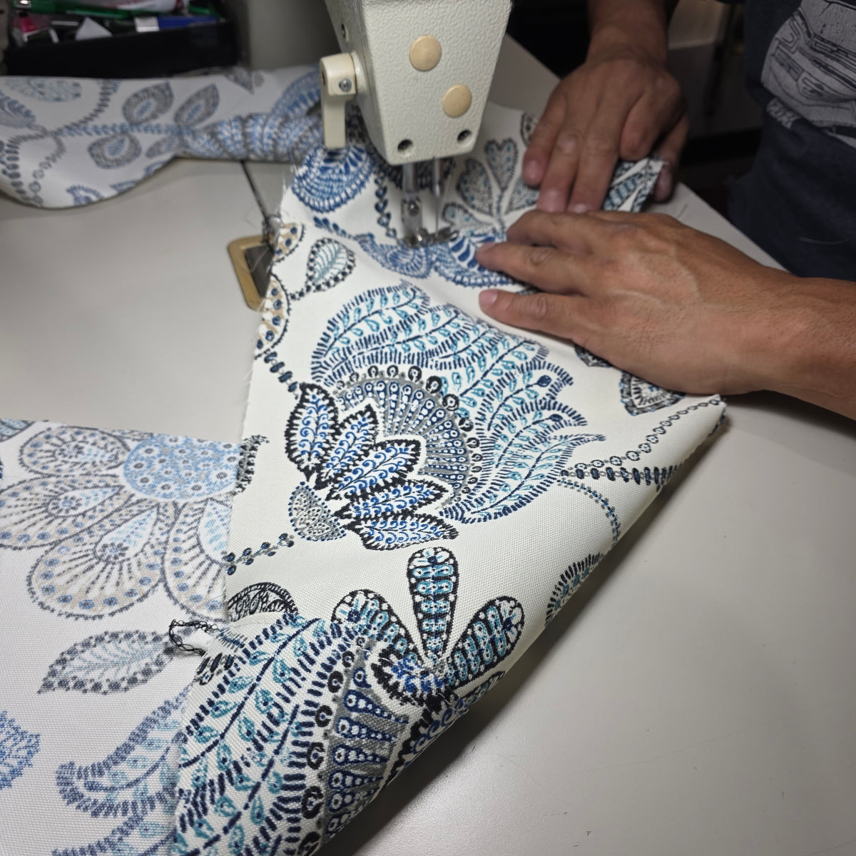 Blue and Cream Flowers scooter seat cover being sewn on an industrial machine, showing the handmade construction by Cheeky Seats.