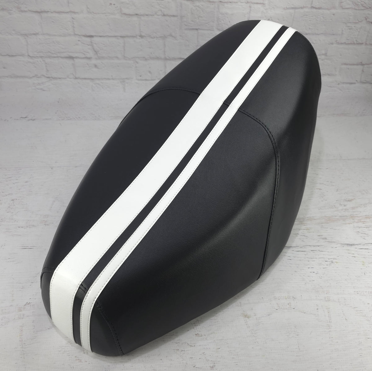 Black Cheeky Seats cover for a Genuine Buddy with dual white racing stripes, front studio view