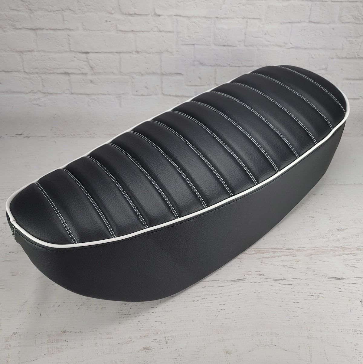 Black tuck-and-roll Honda DAX 125 seat cover with white double stitching and white piping, handmade by Cheeky Seats