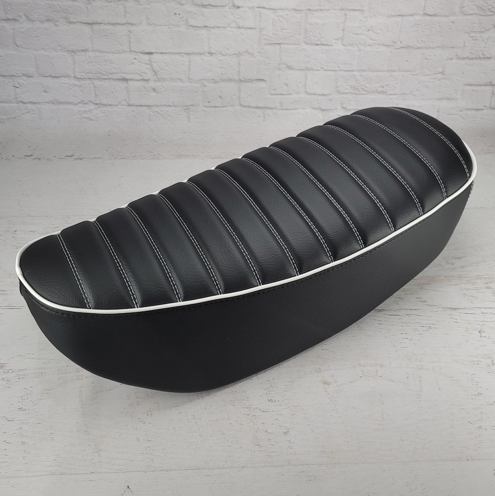 Black tuck-and-roll Honda DAX 125 seat cover with crisp white double stitching and white piping, handmade by Cheeky Seats
