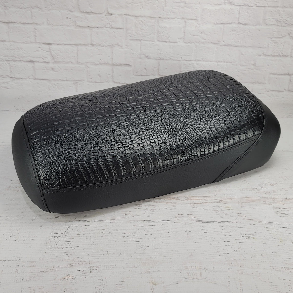 Side and front view of the all-black faux crocodile seat cover showing the textured top and smooth black side panels, handmade by Cheeky Seats