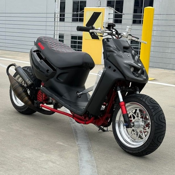 Double Diamond seat cover fitted to a customized black Yamaha Zuma 50, showing the tailored performance-scooter profile, handmade by Cheeky Seats.