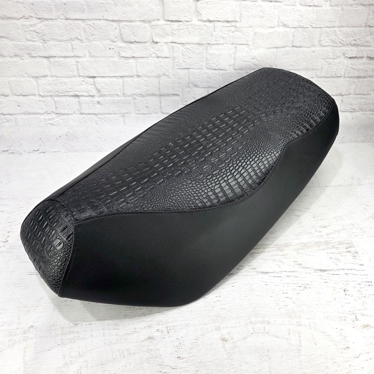 Black Croc and Gator Yamaha Zuma 50 seat cover with an embossed reptile-texture center and smooth side panels, handmade by Cheeky Seats.