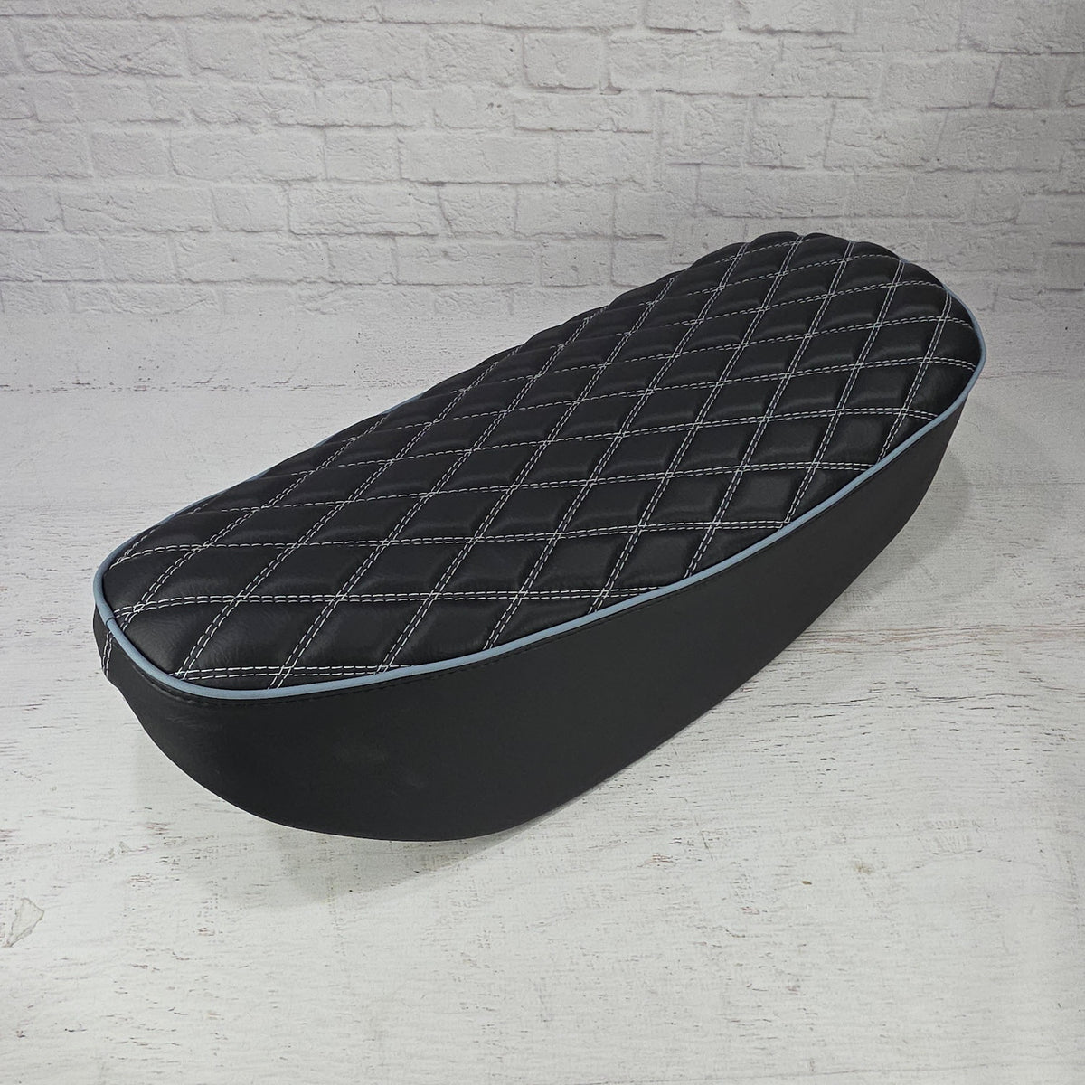 Black double-diamond Honda DAX 125 seat cover with white stitching and pale blue piping, handmade by Cheeky Seats