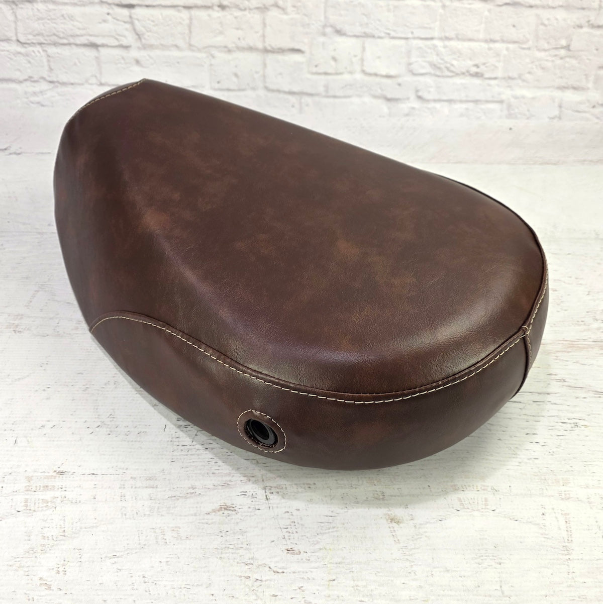 Rear view of the whiskey brown Kymco People 50 seat cover showing the reinforced lock-opening grommet and tan contrast stitching detail, handmade by Cheeky Seats