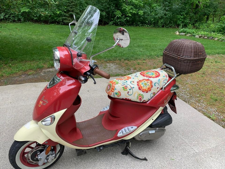 Red-and-cream Genuine Buddy with an ecru floral Cheeky Seats cover and wicker top case
