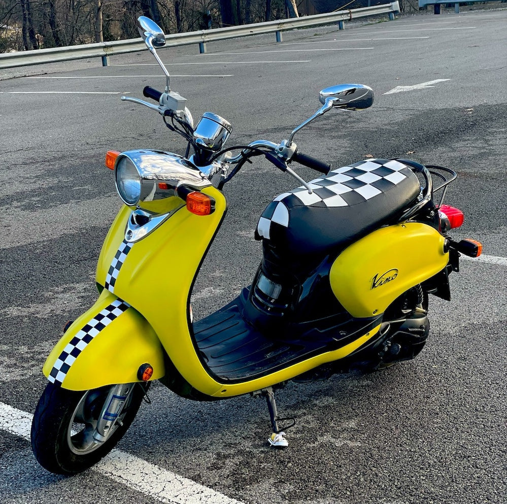 Checkers seat cover fitted to a yellow Yamaha Vino 125 with matching checkerboard body accents, handmade by Cheeky Seats.